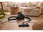 Aspirador Silvercrest® numa sala de estar com tapete claro e sofá.