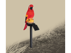 Red parrot solar garden light with a solar panel, illuminating a garden bed.