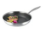 Stainless steel frying pan with a honeycomb pattern, containing cooked steak and vegetables.