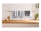Kitchen towels in various grey and white patterns hanging on a wooden rail above a countertop.