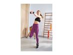 Woman in black sports bra and purple leggings exercising with dumbbells.