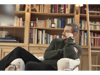 Man wearing an esmara® men's chunky knitted jumper, sitting in a library.