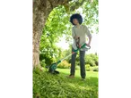 Jaunas žmogus naudoja Parkside vejapjovę žolės pjovimui sode.