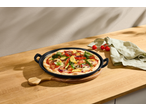 Pizza de vegetais numa placa de ferro fundido SILVERCREST sobre uma bancada de madeira.