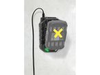 A power tool battery charger with a battery inserted, mounted on a white wall.