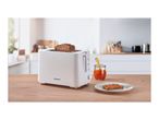 White toaster with two slices of whole grain bread, jam, and a piece of toast with jam.