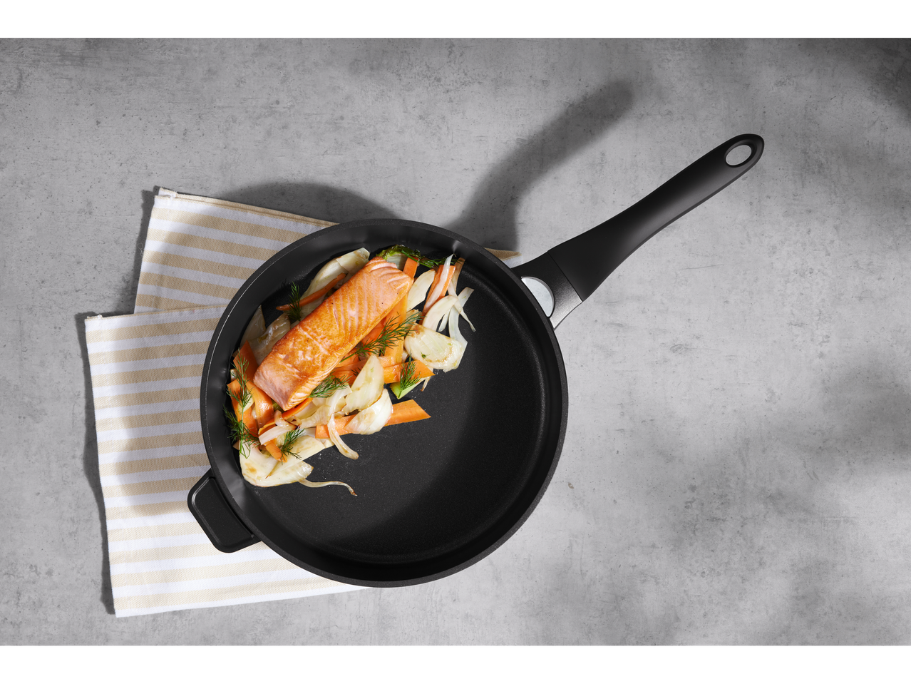 Frigideira de alumínio Silvercrest® com salmão e vegetais em superfície cinzenta.