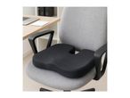 Black ergonomic seat cushion on a grey office chair in a home office setting.