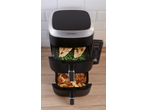 Dual-basket air fryer with chicken and green beans in the top basket, and chicken wings and fries in the bottom.