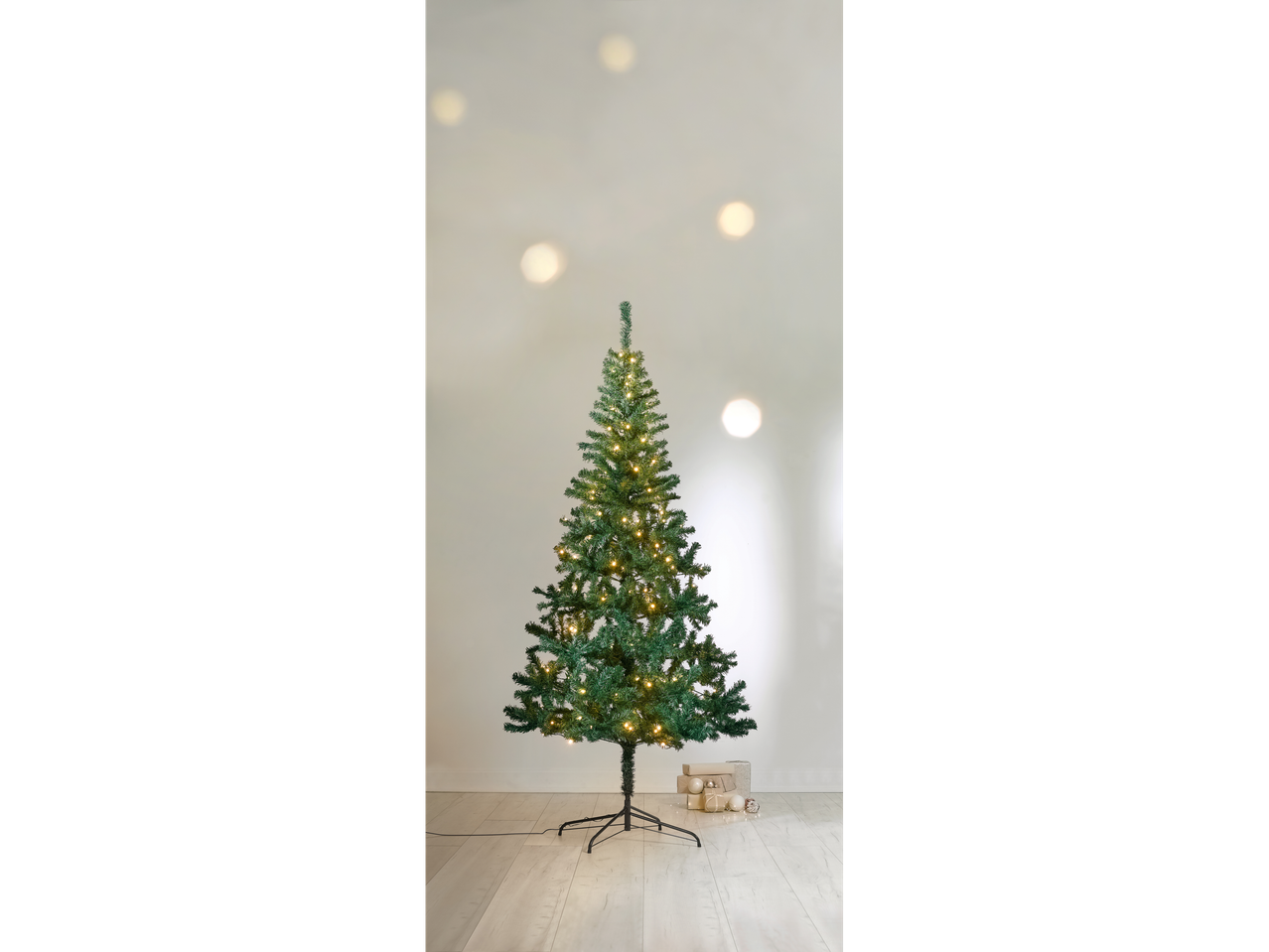 LIVARNO home Pre-Lit Christmas Tree with warm white lights and gifts at its base.