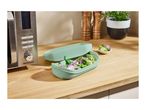 A SilverCrest microwave and a light green steamer filled with vegetables on a wooden counter.