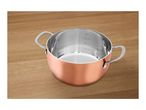 Copper-colored stainless steel cooking pot with measurement markings on a wooden surface