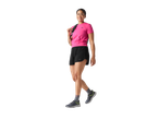 Mulher com camiseta rosa, shorts pretos e tênis esportivos.