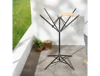 A person opens a black, foldable laundry drying rack with multiple lines on a patio.