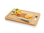 Bamboo cutting board with oranges, limes, and a knife.