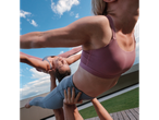 Mulheres em sutiãs desportivos Crivit e leggings, a fazer acrobacias ao ar livre.