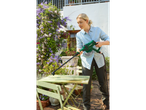 Woman cleaning garden furniture with a Parkside pressure washer.