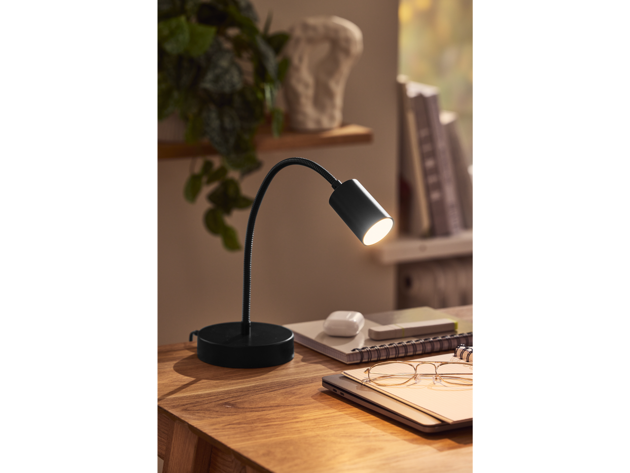 LIVARNO LED stona/opružna lampa na drvenom stolu sa sveskama i naočarima.