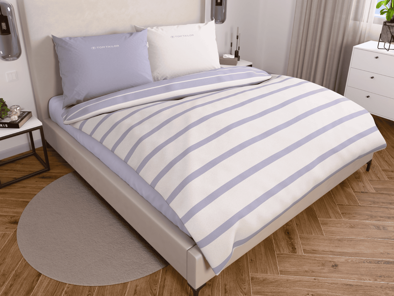 Bett mit gestreifter Bettwäsche von Tom Tailor, Nachttisch und Kommode in einem Schlafzimmer.