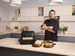 Chef with Philips Air Fryer and lasagna in a modern kitchen.