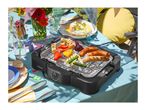 Electric grill with sausages, halloumi, and vegetables on a festive outdoor table.