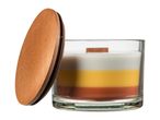 A layered candle in a glass jar with a wooden lid leaning against it.