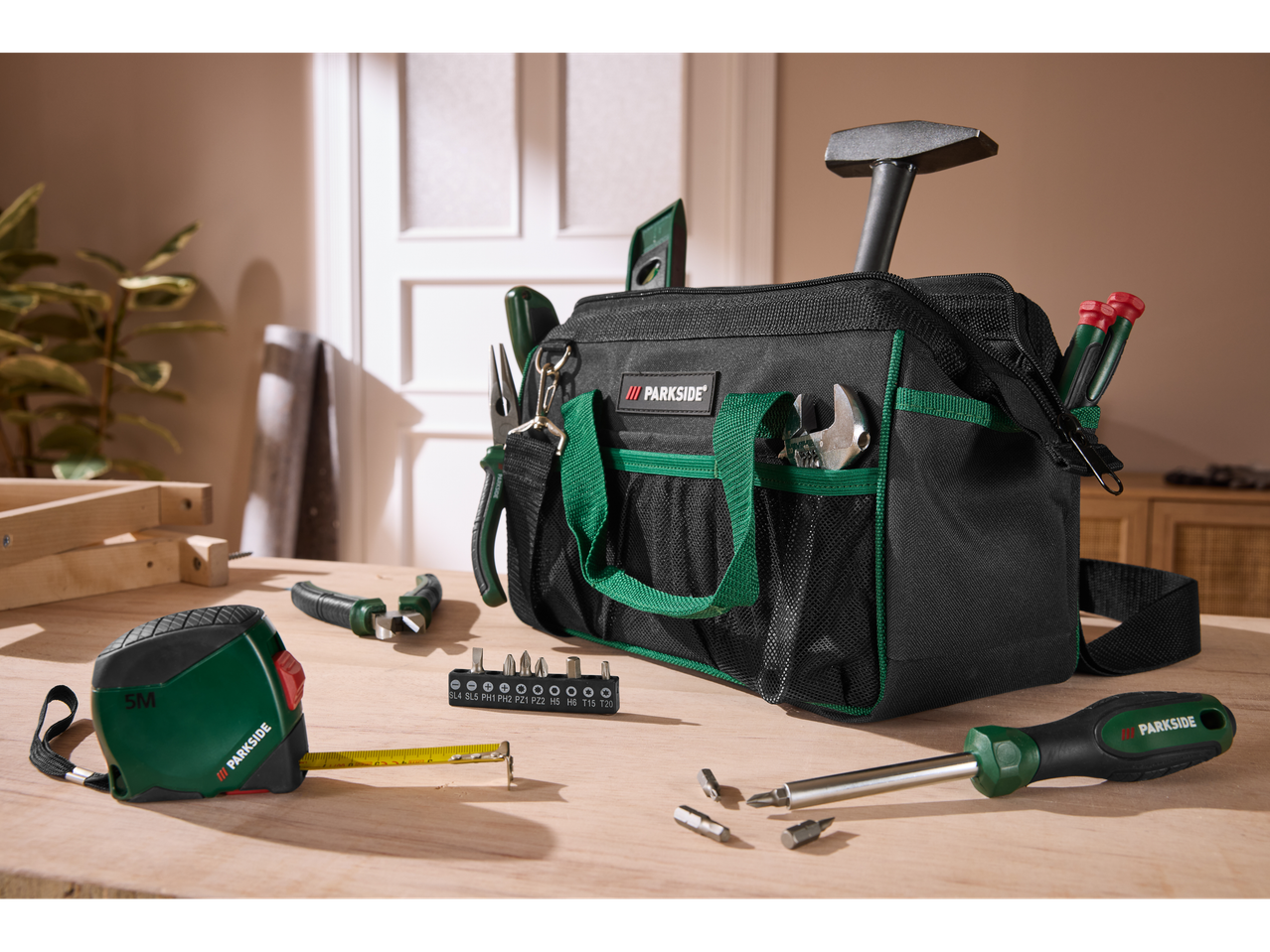 Parkside Werkzeugtasche mit Werkzeugen und Maßband auf einem Holztisch.