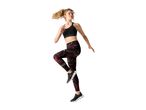 Woman in black sports bra and patterned leggings exercising