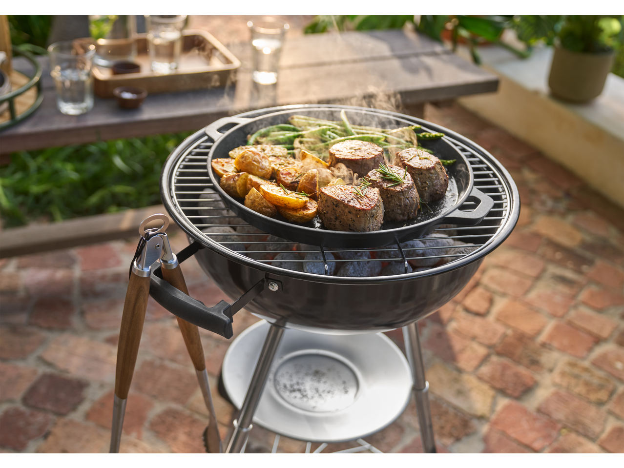 Grillmeister Cast Iron Grill Pan/Plate with steak, potatoes, and green beans on a charcoal grill.