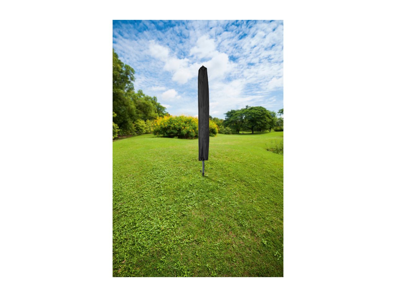 Black parasol cover on a stand in a green garden with trees and blue sky.