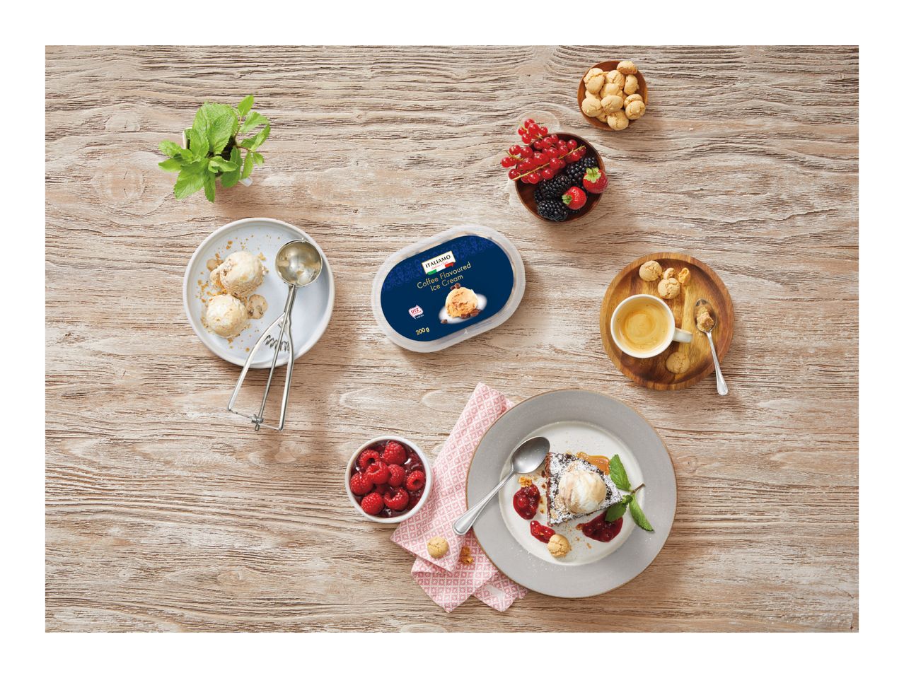 Overhead shot of coffee ice cream tub, scoops on a plate, and a dessert with berries.