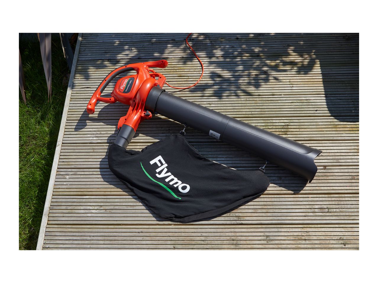 Flymo PowerVac 3000 leaf blower with collection bag on a wooden deck.