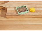 Vegetable slicer and daikon slices on a wooden cutting board.