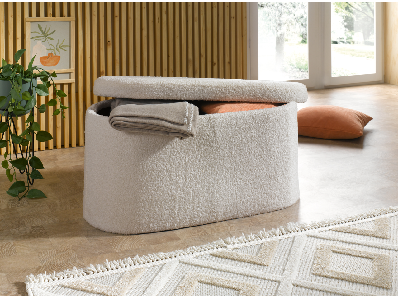 Otoman de depozitare LIVARNO home într-un living cu o plantă și un covor.