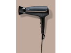 Secador de cabelo preto com detalhes dourados sobre fundo bege.