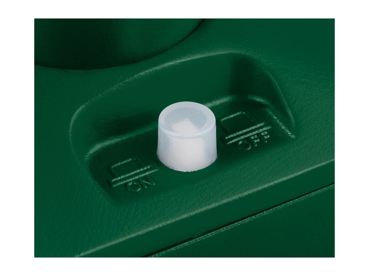 Close-up of a green plastic device with a white button and 'ON' and 'OFF' labels.