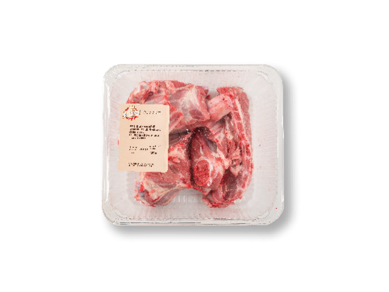 Iepakojums ar jēra gaļas gabaliņiem uz melna fona.