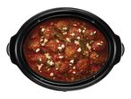 Meatballs in tomato sauce with feta cheese and herbs in a slow cooker
