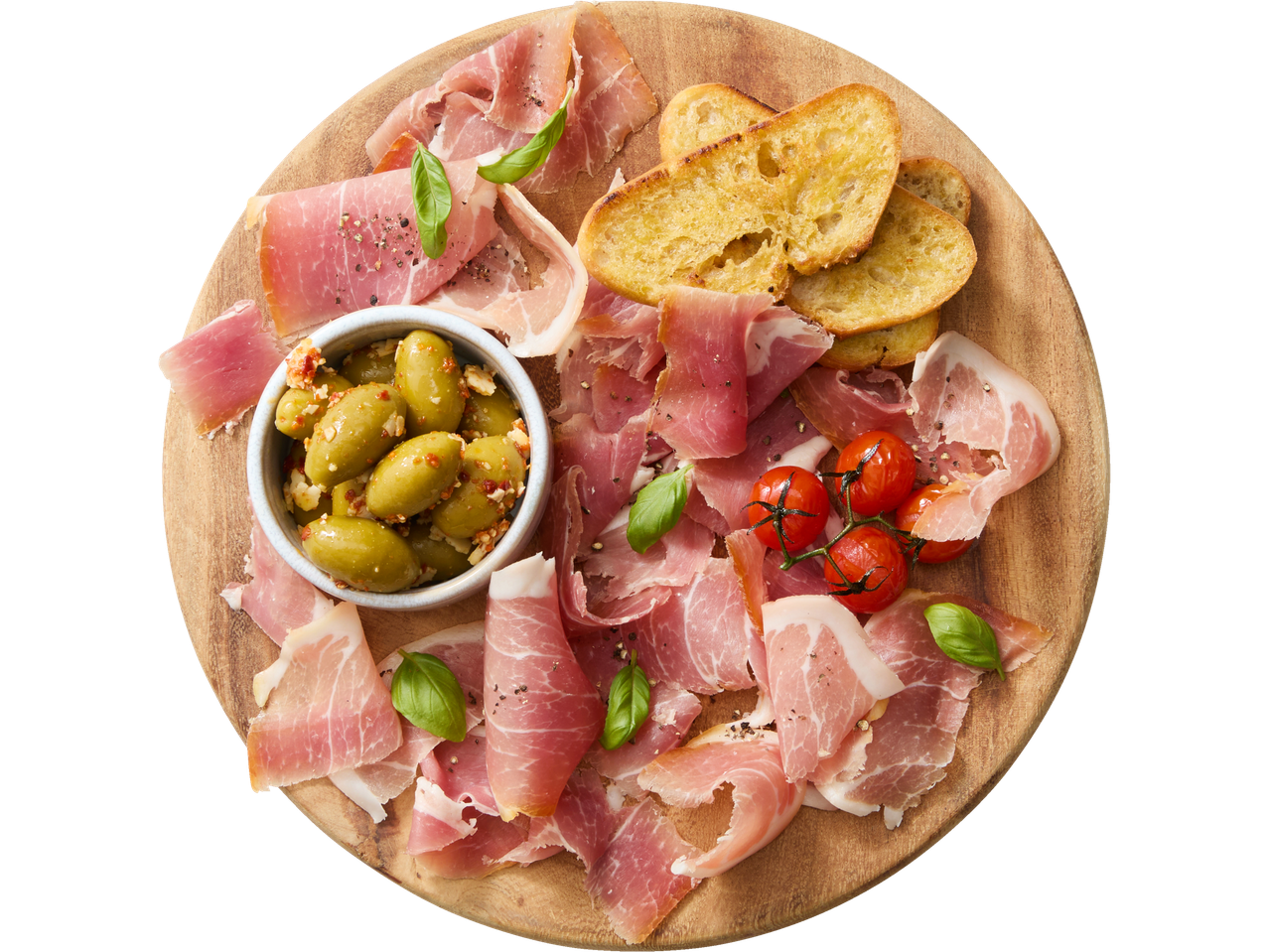 Charcuterie board with prosciutto, olives, cherry tomatoes, basil, and toasted bread.