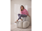Bljije vrouw in roze Esmara pyjama en bedrukte broek zit op een stoel.