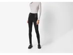 Femeie în jeggings modelatori negri Esmara și maletă gri deschis.