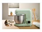 A mint green SilverCrest stand mixer with a stainless steel bowl on a wooden table.