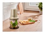 SilverCrest food chopper with basil and oil, next to cheese and pine nuts on a wooden board.