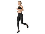 Woman running in black sports bra and leggings.