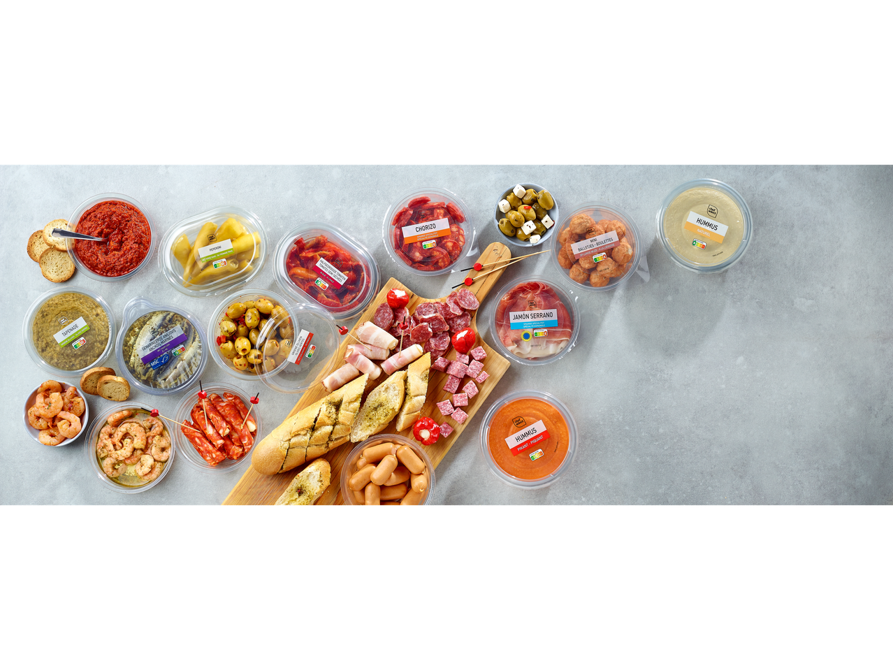 Vitasia Jūras velšu uzkodas : un assortiment de tapas et de trempettes, dont du chorizo, du jambon, des olives et du houmous.