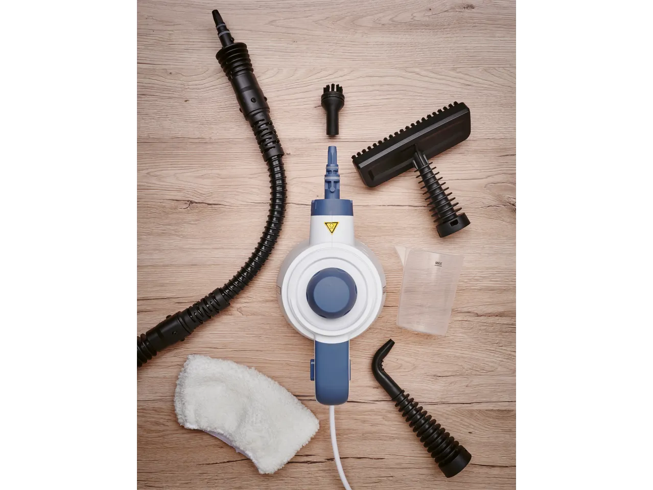 A steam cleaner with various attachments, including brushes, nozzles, a measuring cup, and a cloth.