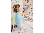 Bambina che gioca con numeri magnetici su una lavagna bianca.