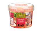 En beholder med økologisk kimchi i koreansk stil, med grøntsager og krydderier.