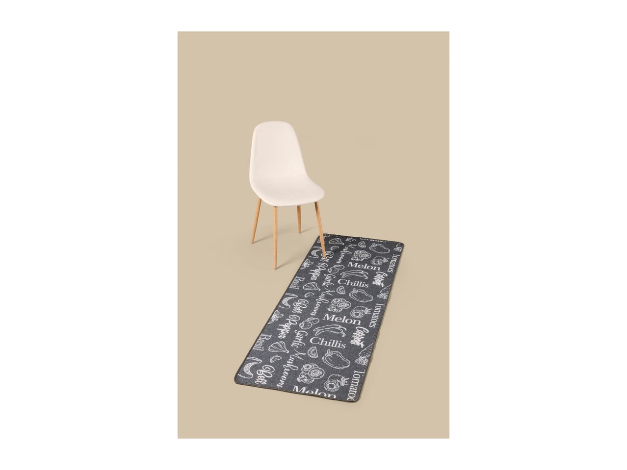 A long kitchen runner rug with a chalkboard-style vegetable pattern next to a chair