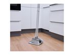 Broom and dustpan set on a wooden floor in a modern kitchen.